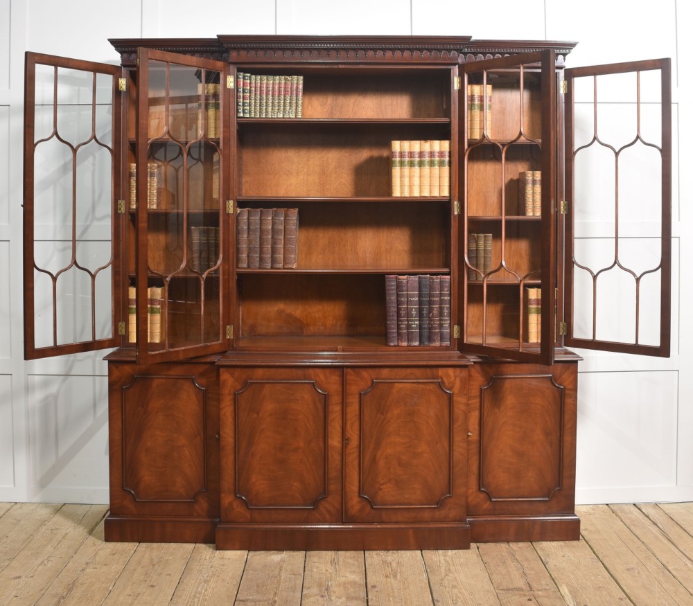 A large Regency Revival flame mahogany breakfront library bookcase with astragal glazed upper doors and panelled cupboard base. View VI