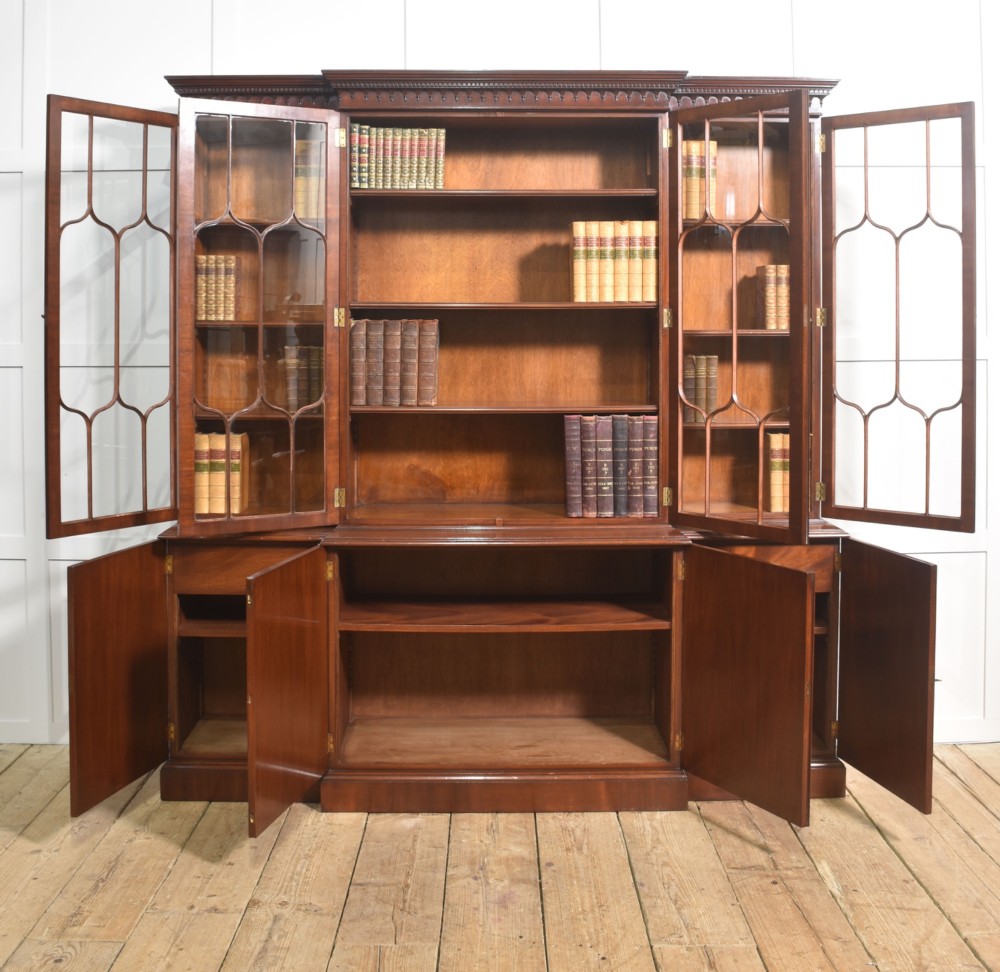 A large Regency Revival flame mahogany breakfront library bookcase with astragal glazed upper doors and panelled cupboard base. View VII