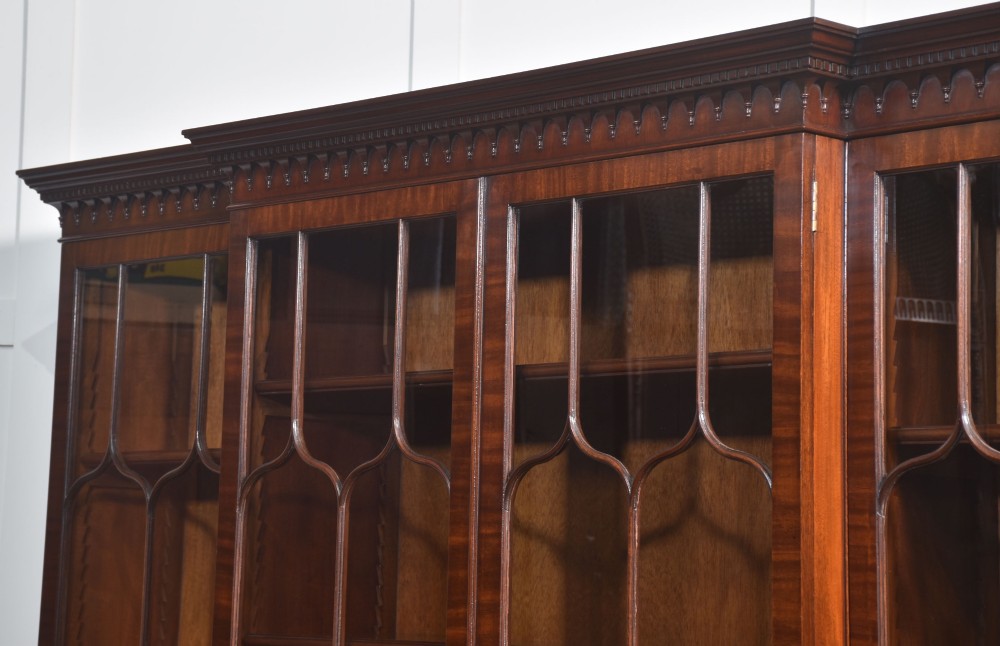 A large Regency Revival flame mahogany breakfront library bookcase with astragal glazed upper doors and panelled cupboard base. View XIII