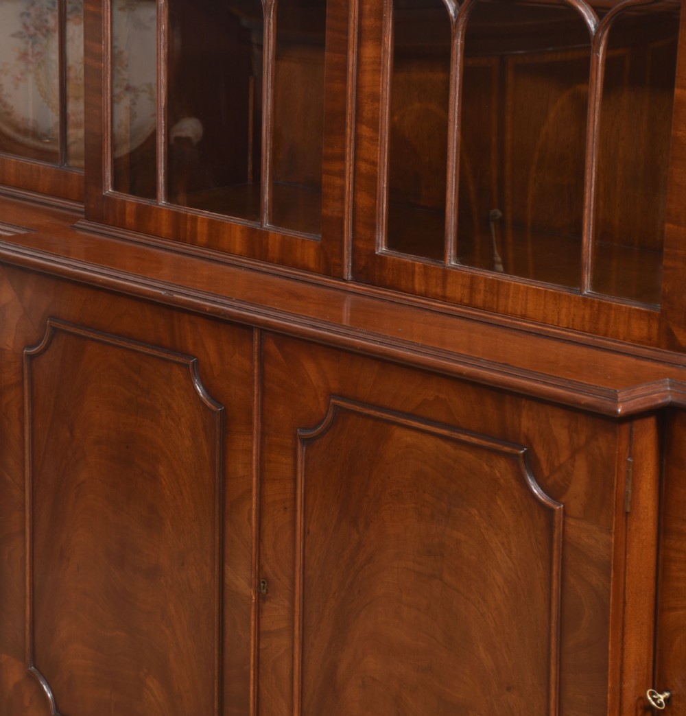 A large Regency Revival flame mahogany breakfront library bookcase with astragal glazed upper doors and panelled cupboard base. View XIV