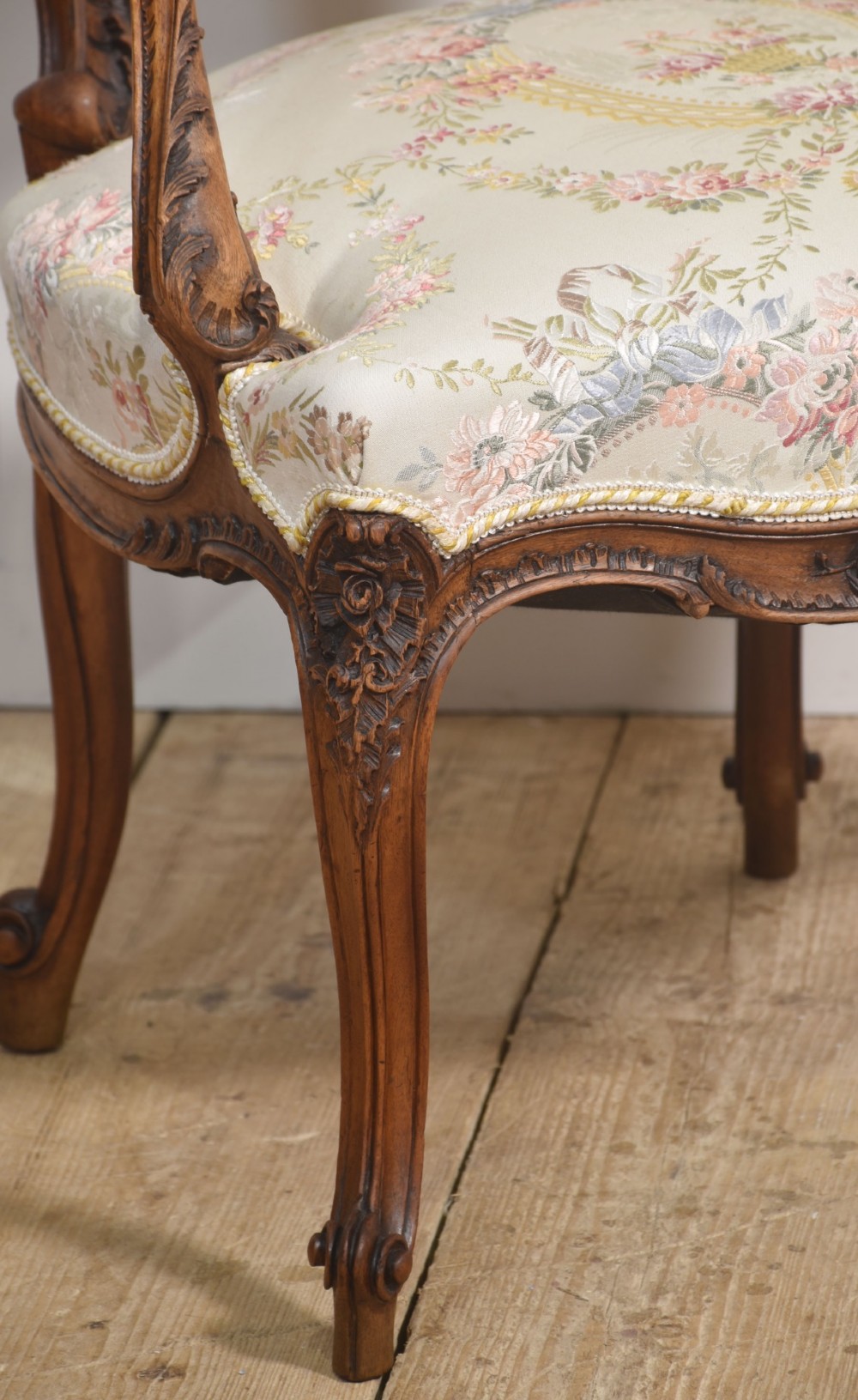 A pair of French carved walnut open armchairs featuring floral tapestry upholstery and cabriole legs. View VII