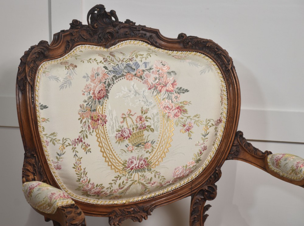 A pair of French carved walnut open armchairs featuring floral tapestry upholstery and cabriole legs. View IX