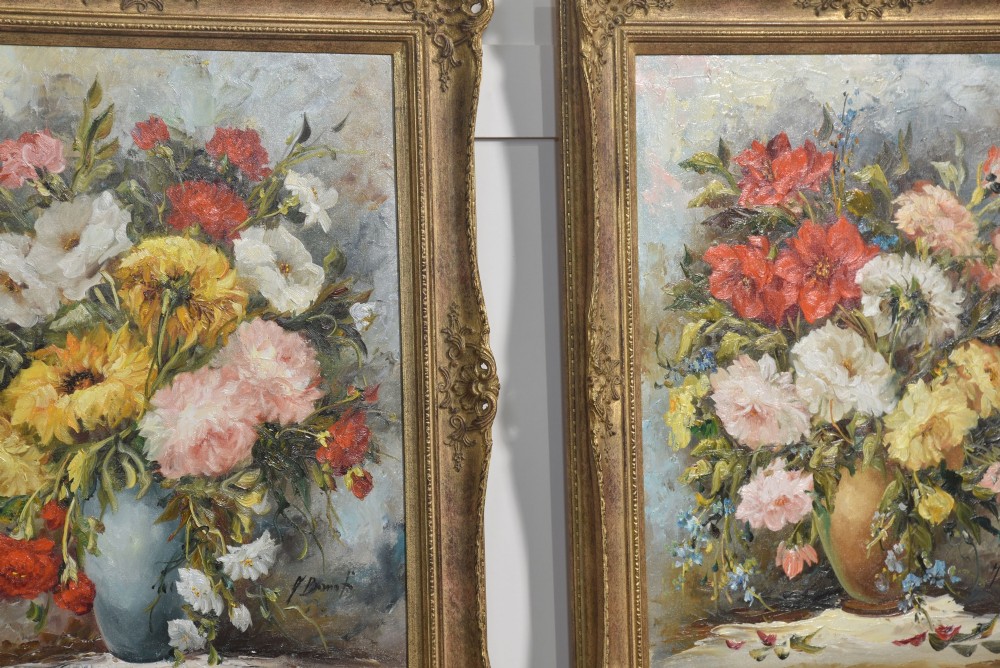 A pair of framed oil paintings depicting colourful arrangements of flowers in ceramic vases set within ornate gilded frames. View VI