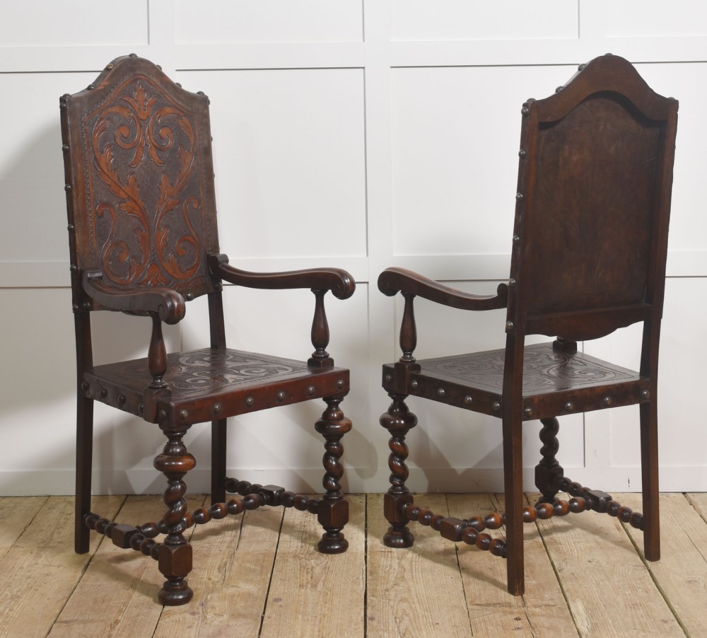 A set of eight dark brown walnut dining chairs featuring embossed floral leather seats and backrests with decorative studding and barley twist legs. View VII
