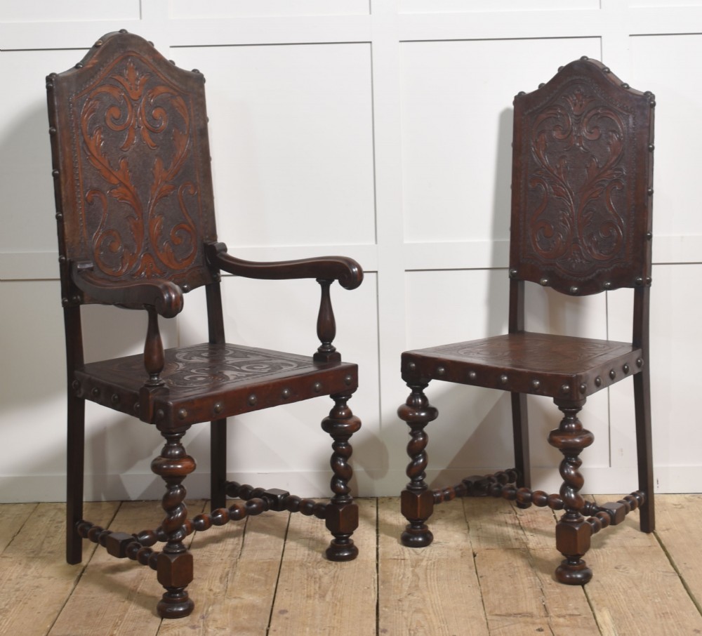 A set of eight dark brown walnut dining chairs featuring embossed floral leather seats and backrests with decorative studding and barley twist legs. View VIII