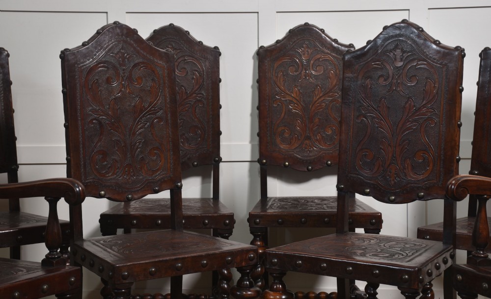 A set of eight dark brown walnut dining chairs featuring embossed floral leather seats and backrests with decorative studding and barley twist legs. View XI