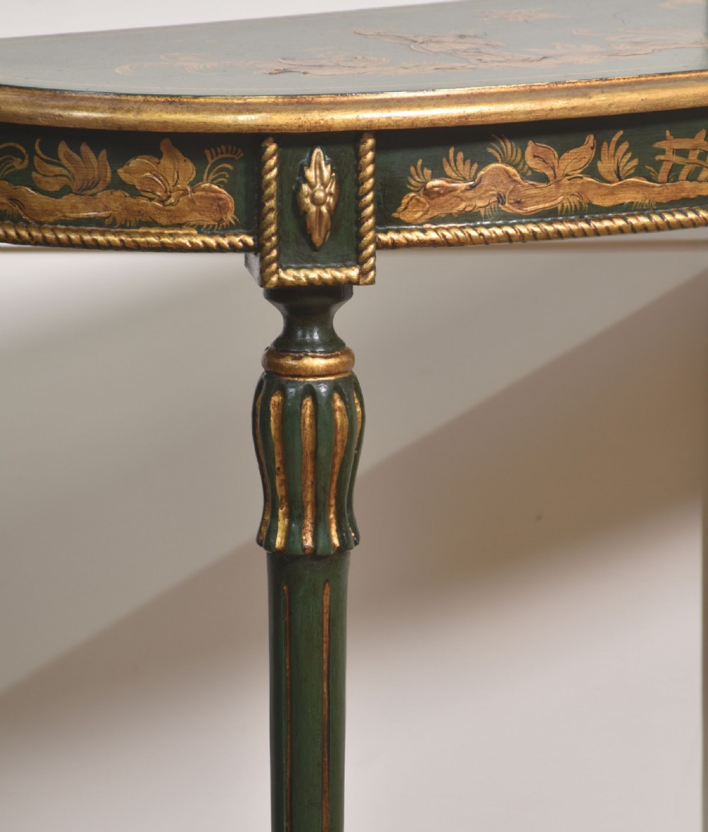 A dark green demi-lune console table with hand-painted gold chinoiserie decoration along the frieze and fluted tapered legs. View V