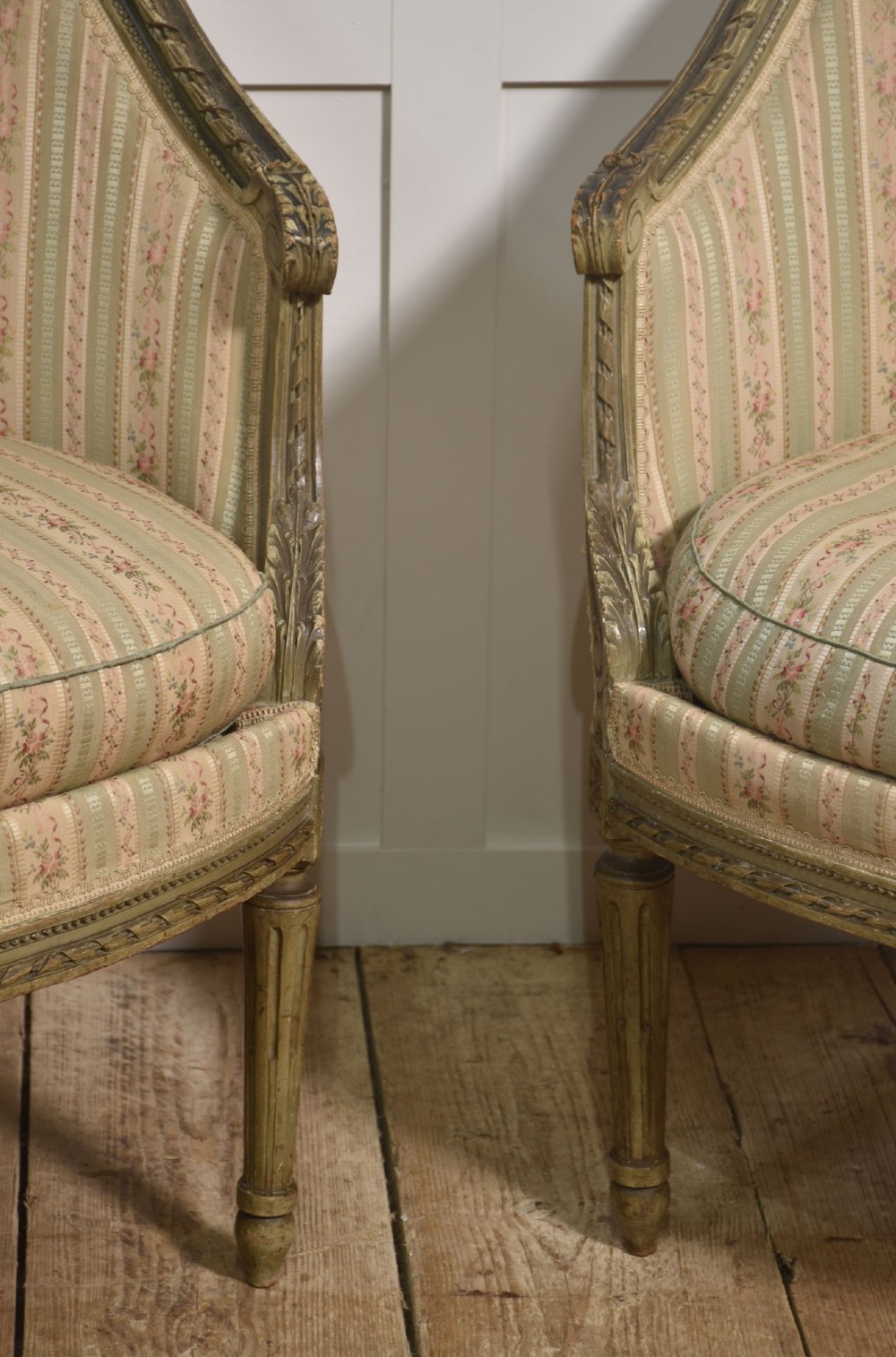 A pair of grey-painted French tub armchairs upholstered in a striped floral pastel fabric with fluted legs. View V