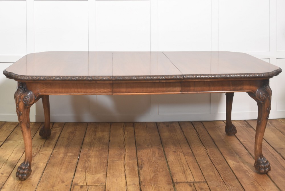 A carved walnut extending dining table resting on four cabriole legs with carved knees and claw and ball feet. View III
