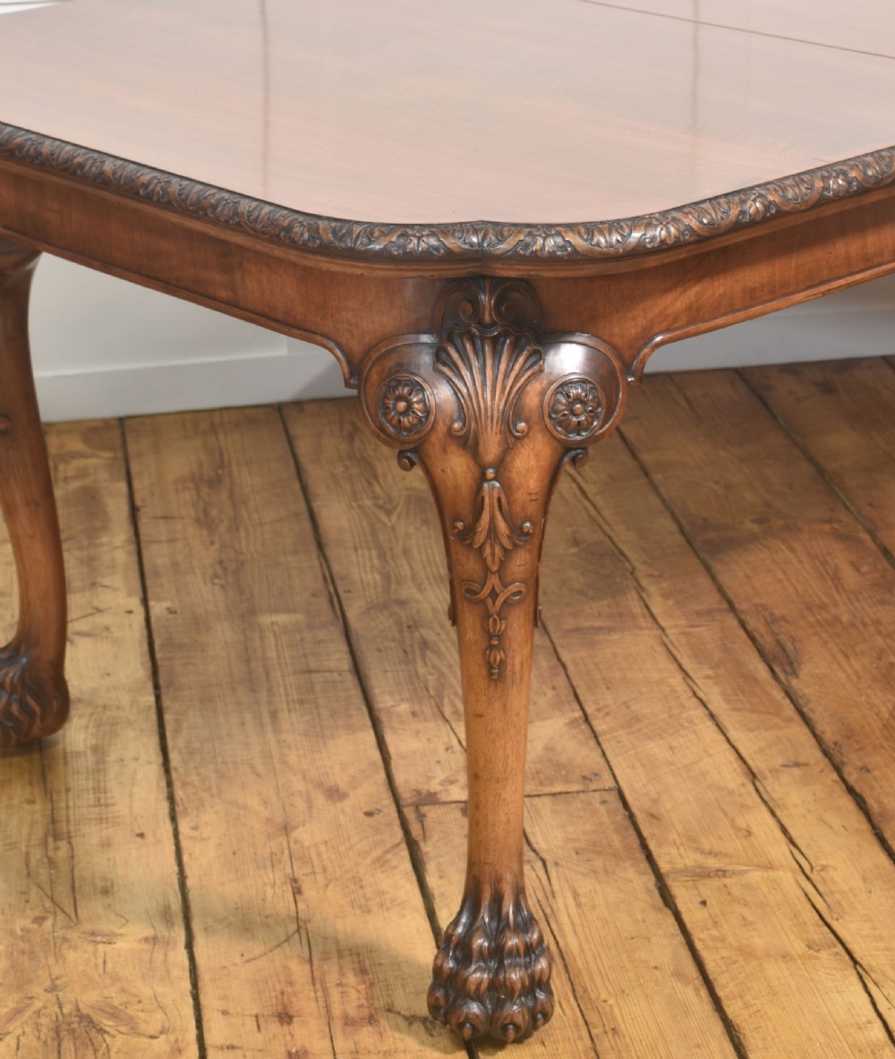 A carved walnut extending dining table resting on four cabriole legs with carved knees and claw and ball feet. View IV