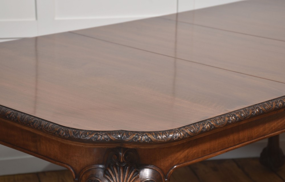 A carved walnut extending dining table resting on four cabriole legs with carved knees and claw and ball feet. View V