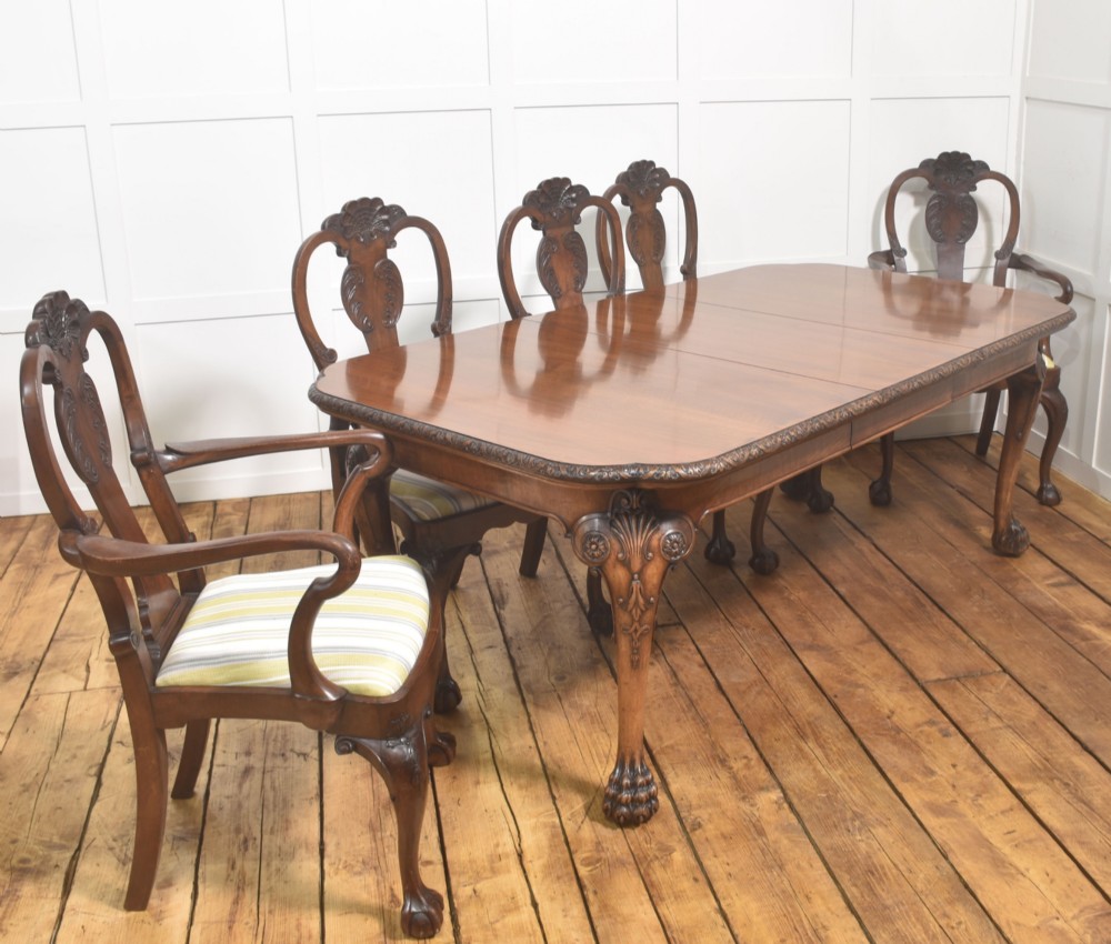 A carved walnut extending dining table resting on four cabriole legs with carved knees and claw and ball feet. View VII
