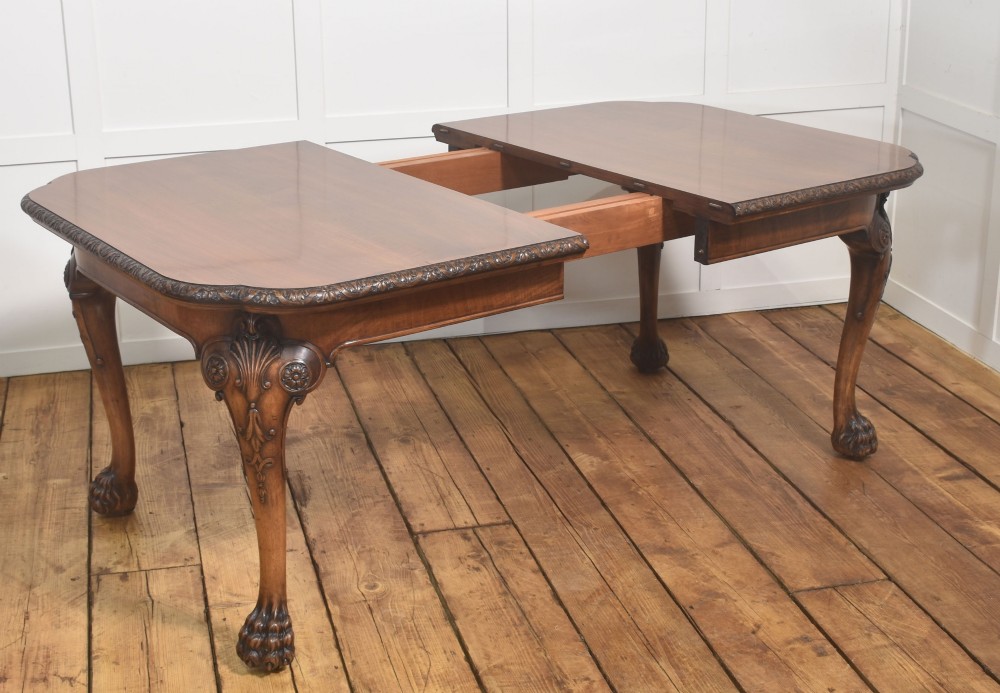 A carved walnut extending dining table resting on four cabriole legs with carved knees and claw and ball feet. View VIII