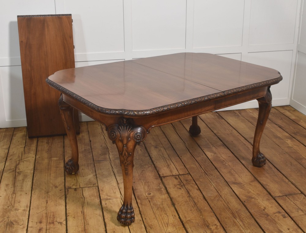 A carved walnut extending dining table resting on four cabriole legs with carved knees and claw and ball feet. View IX