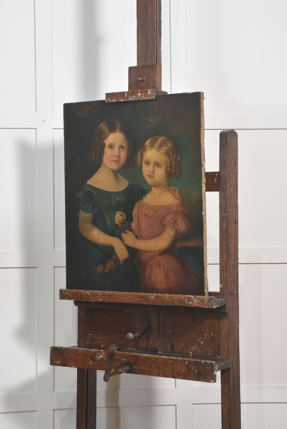 A late nineteenth-century dark oak artist studio easel featuring an adjustable central shaft, crank handle, and cast iron castors on an H-frame base. View V