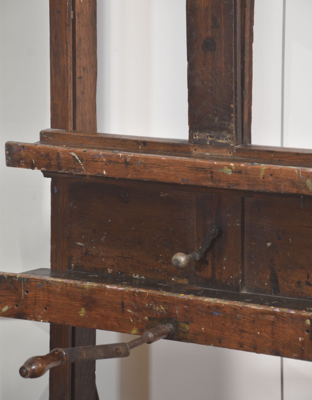 A late nineteenth-century dark oak artist studio easel featuring an adjustable central shaft, crank handle, and cast iron castors on an H-frame base. View XI