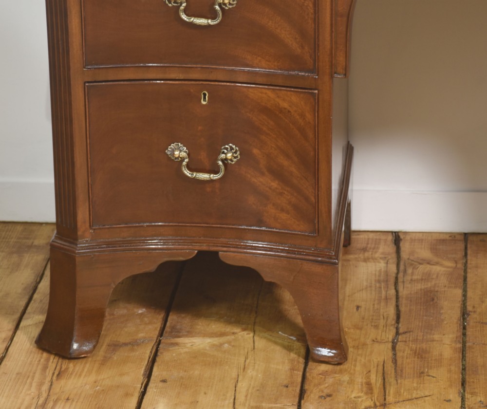 A mahogany serpentine-fronted dressing table featuring nine drawers with brass swan-neck handles and a shaped central kneehole. View IV