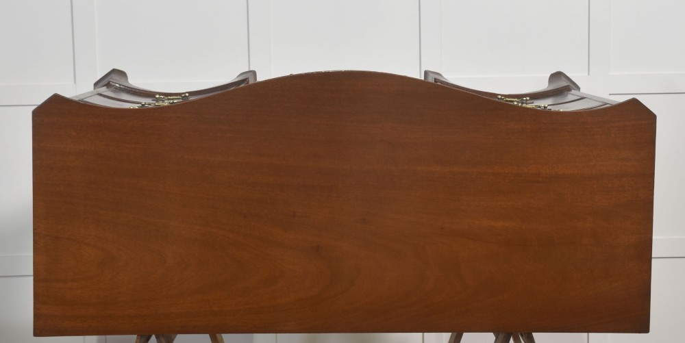 A mahogany serpentine-fronted dressing table featuring nine drawers with brass swan-neck handles and a shaped central kneehole. View X