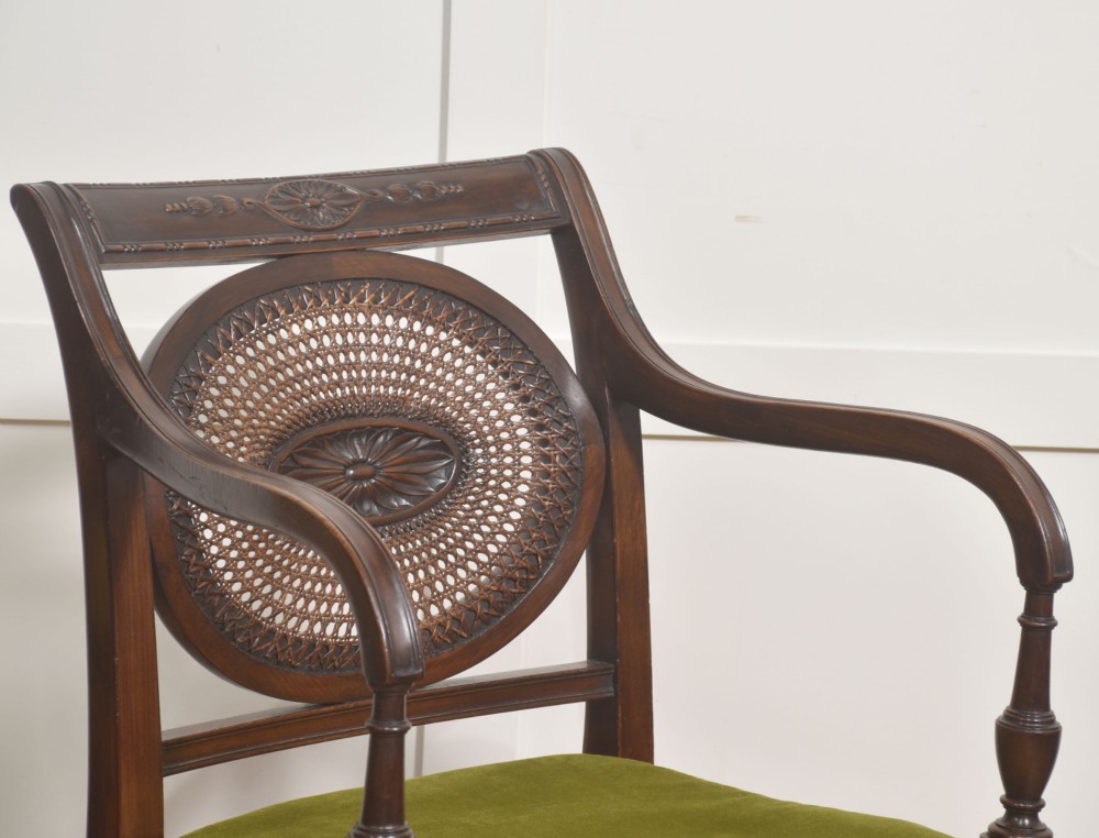 Sheraton Revival mahogany armchair featuring an oval cane back panel with carved central medallion, olive green velvet seat cushion, and turned fluted front legs. View III