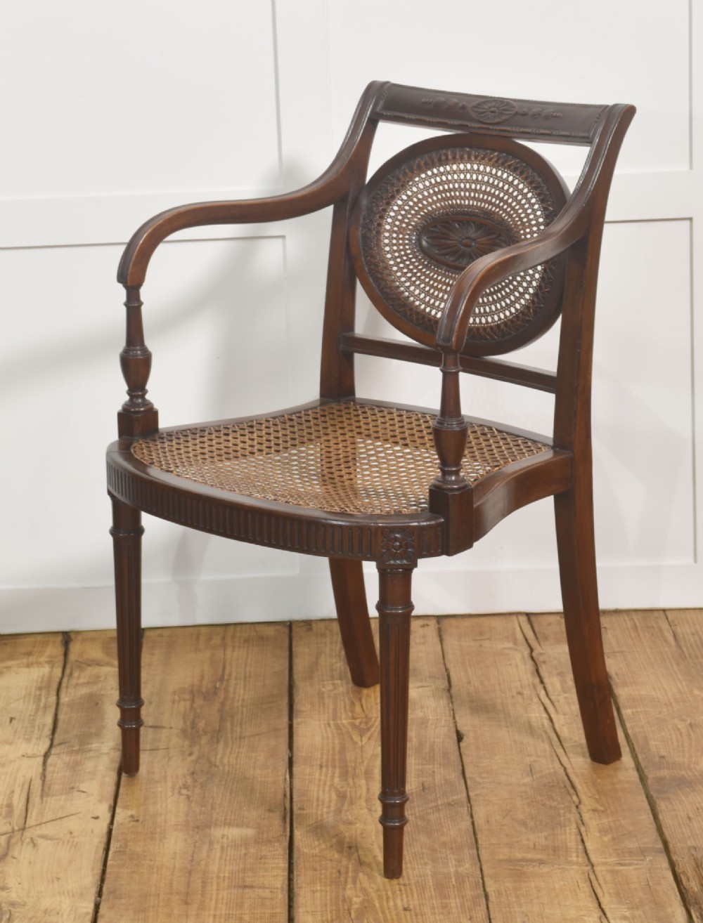 Sheraton Revival mahogany armchair featuring an oval cane back panel with carved central medallion, olive green velvet seat cushion, and turned fluted front legs. View VIII