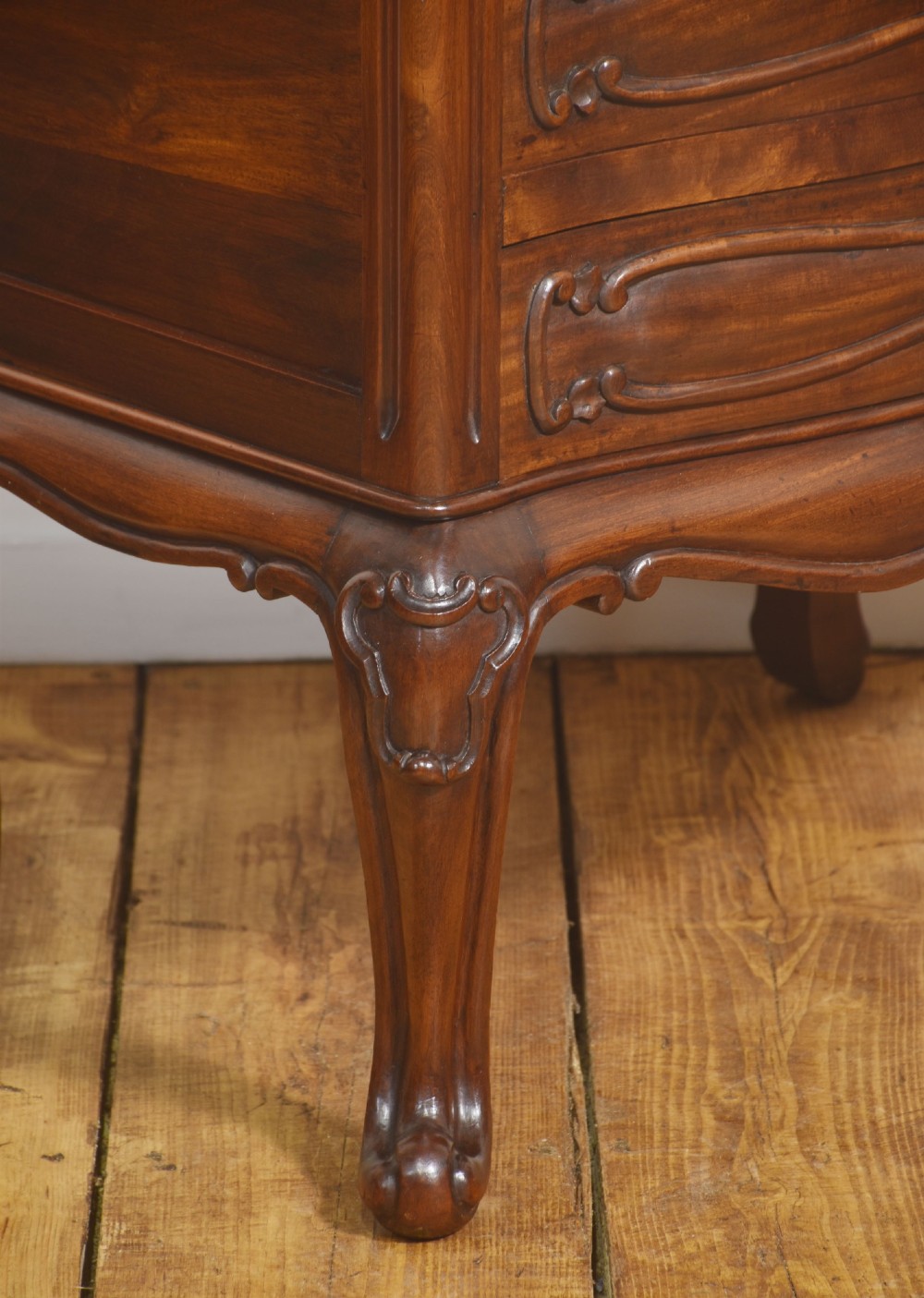 A French Louis XV style walnut chest featuring three carved drawers elevated on cabriole legs with brass drop handles. View V