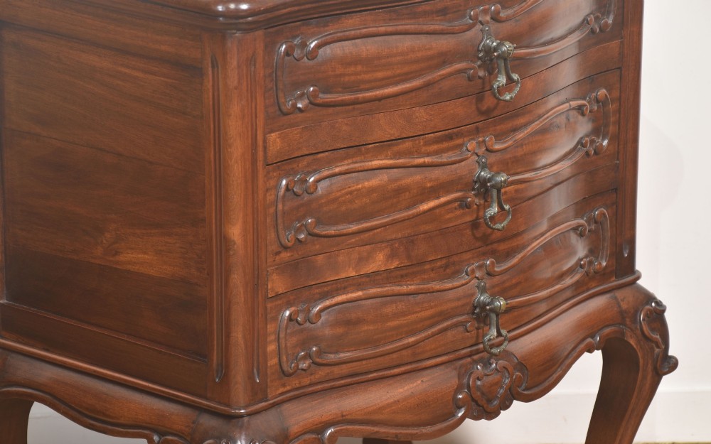 A French Louis XV style walnut chest featuring three carved drawers elevated on cabriole legs with brass drop handles. View VI