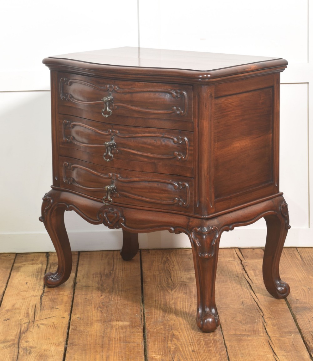 A French Louis XV style walnut chest featuring three carved drawers elevated on cabriole legs with brass drop handles. View VII