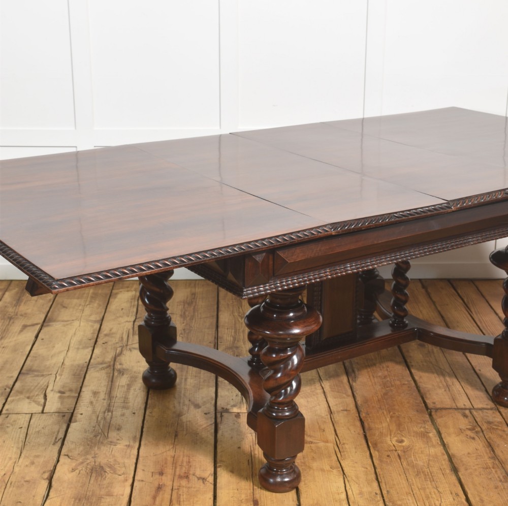 A large 19th-century Portuguese rosewood extending dining table with carved barley-twist legs, an H-stretcher base, and two removable extension leaves standing behind it. View VII