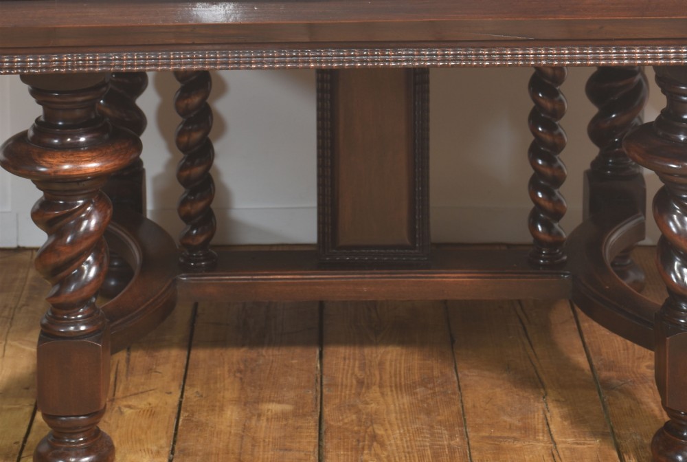 A large 19th-century Portuguese rosewood extending dining table with carved barley-twist legs, an H-stretcher base, and two removable extension leaves standing behind it. View X