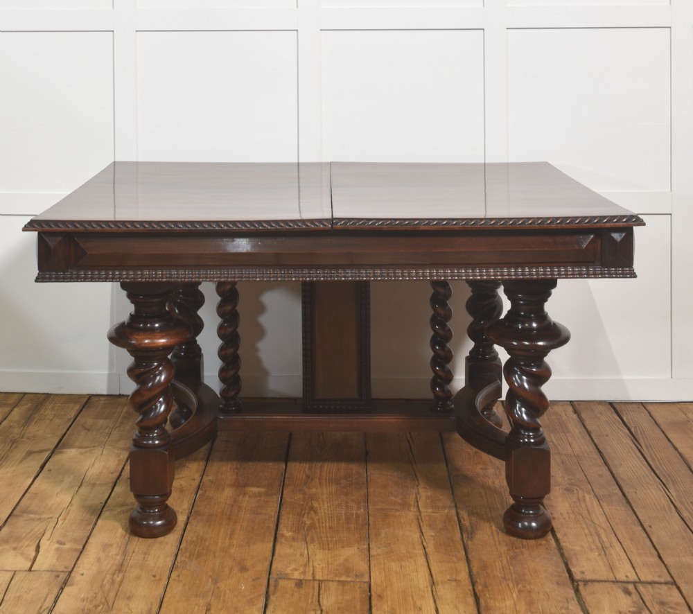A large 19th-century Portuguese rosewood extending dining table with carved barley-twist legs, an H-stretcher base, and two removable extension leaves standing behind it. View XII