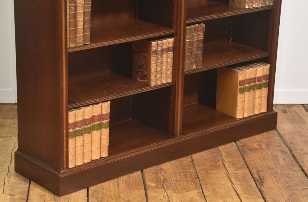 A tall, double-bay mahogany open bookcase featuring delicate satinwood festoon inlays along the top frieze and multiple fixed shelves containing books. View VIII