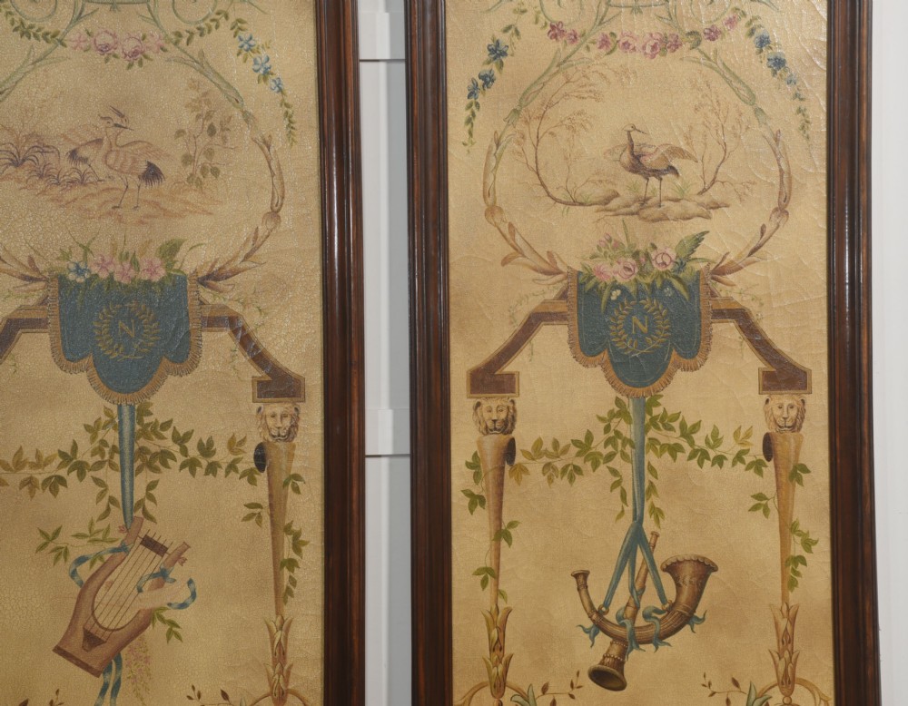 A pair of tall rectangular dark wood framed panels featuring hand-painted Neoclassical motifs, lyres, floral swags, and Napoleonic heraldry on a gold ground. View IX
