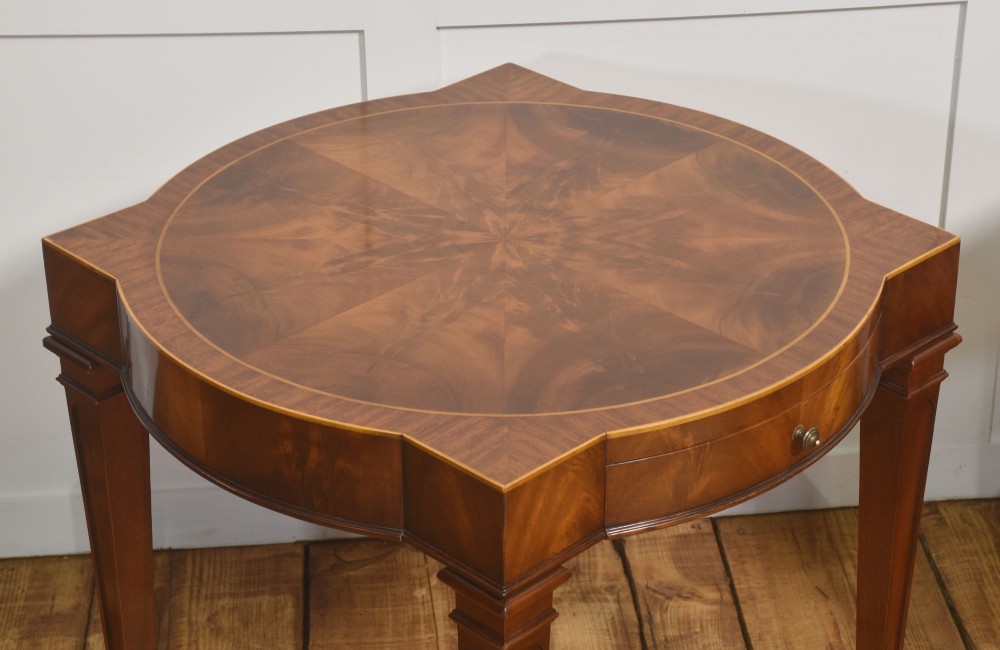 A pair of mahogany Sheraton Revival side tables featuring shaped inlaid tops, single frieze drawers, fluted tapered legs, and brass castors. View XI