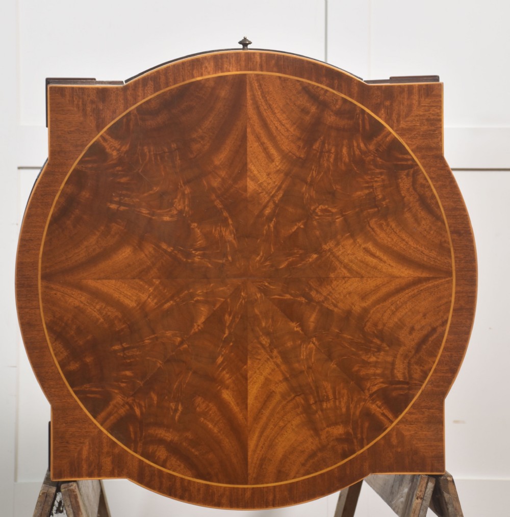 A pair of mahogany Sheraton Revival side tables featuring shaped inlaid tops, single frieze drawers, fluted tapered legs, and brass castors. View XIII