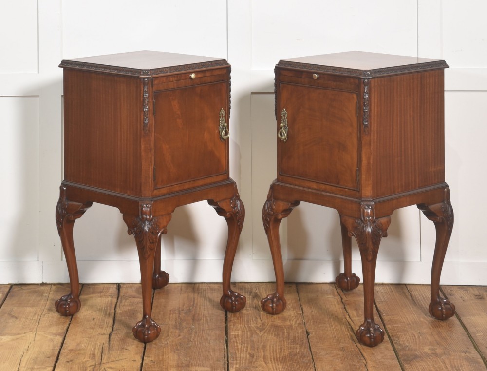 A pair of warm brown mahogany Chippendale style bedside cabinets featuring carved cabriole legs ending in ball and claw feet, flame mahogany single door cupboards, brass drop handles, and pull-out brush slides. View VII
