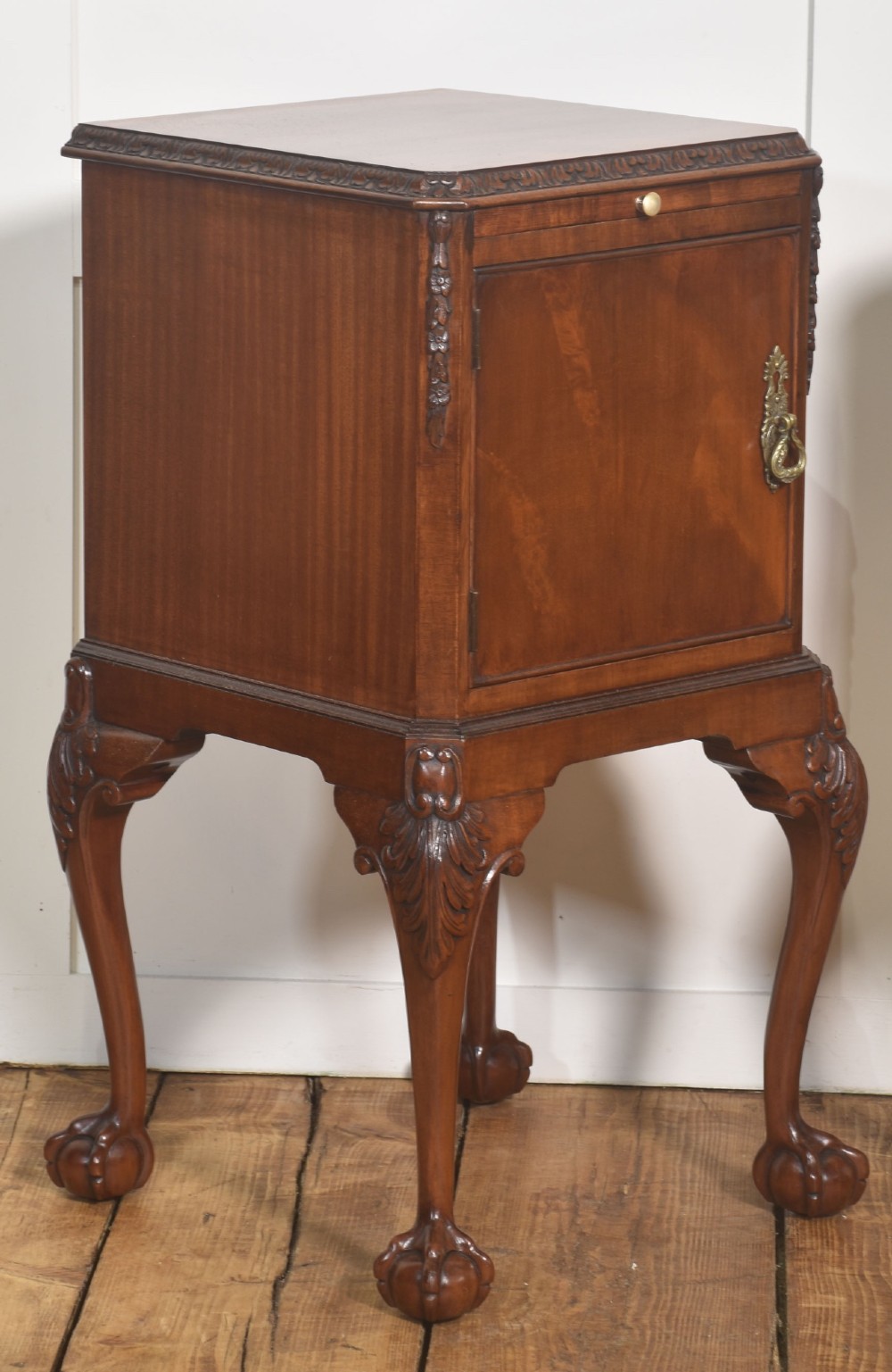 A pair of warm brown mahogany Chippendale style bedside cabinets featuring carved cabriole legs ending in ball and claw feet, flame mahogany single door cupboards, brass drop handles, and pull-out brush slides. View VIII