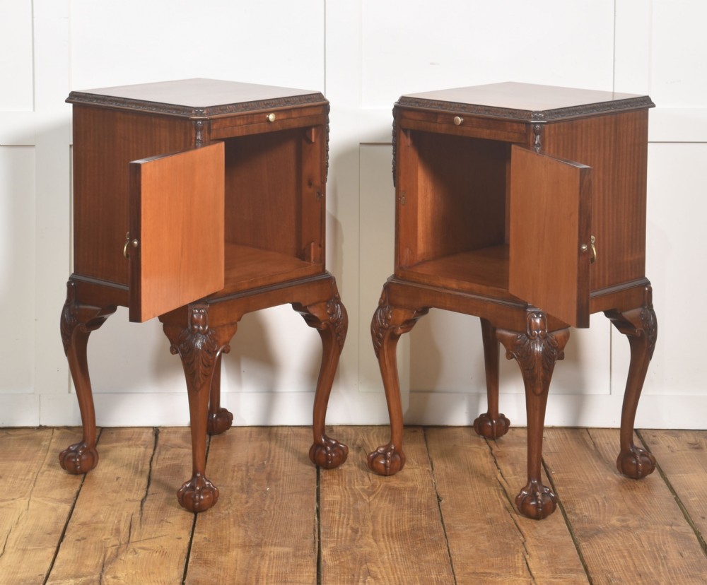 A pair of warm brown mahogany Chippendale style bedside cabinets featuring carved cabriole legs ending in ball and claw feet, flame mahogany single door cupboards, brass drop handles, and pull-out brush slides. View IX