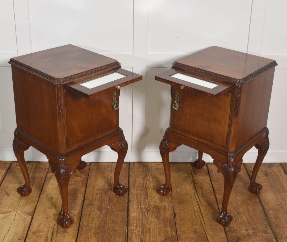 A pair of warm brown mahogany Chippendale style bedside cabinets featuring carved cabriole legs ending in ball and claw feet, flame mahogany single door cupboards, brass drop handles, and pull-out brush slides. View X