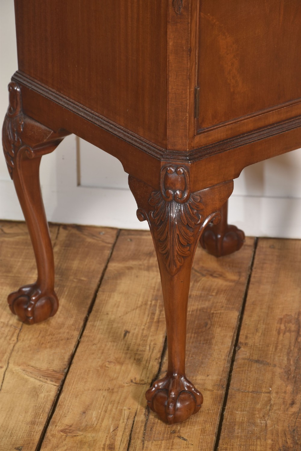 A pair of warm brown mahogany Chippendale style bedside cabinets featuring carved cabriole legs ending in ball and claw feet, flame mahogany single door cupboards, brass drop handles, and pull-out brush slides. View XII