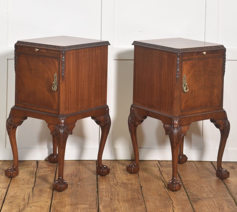 A pair of warm brown mahogany Chippendale style bedside cabinets featuring carved cabriole legs ending in ball and claw feet, flame mahogany single door cupboards, brass drop handles, and pull-out brush slides. View XIII