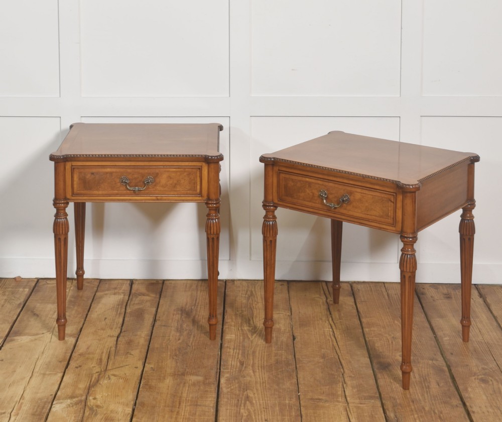 A pair of Edwardian walnut side tables featuring single drawers with brass handles and fluted turned legs. View VI