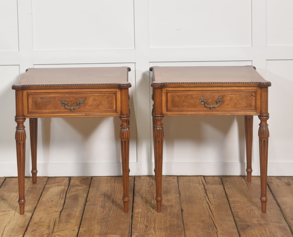 A pair of Edwardian walnut side tables featuring single drawers with brass handles and fluted turned legs. View VII