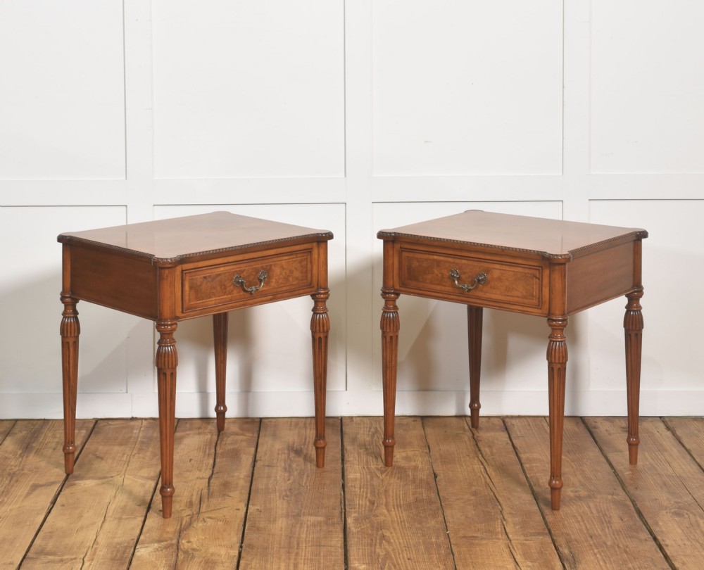 A pair of Edwardian walnut side tables featuring single drawers with brass handles and fluted turned legs. View IX