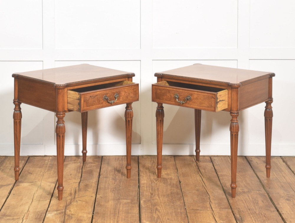 A pair of Edwardian walnut side tables featuring single drawers with brass handles and fluted turned legs. View X