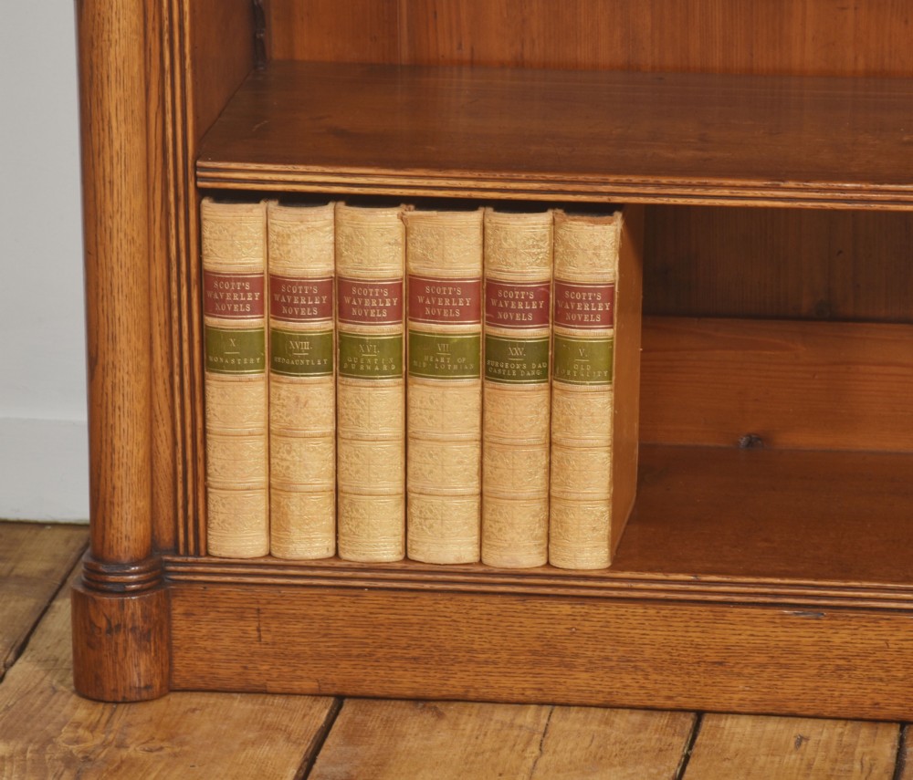 A late nineteenth-century warm brown oak open bookcase featuring three horizontal shelves flanked by fluted side pilasters on a plinth base. View IV