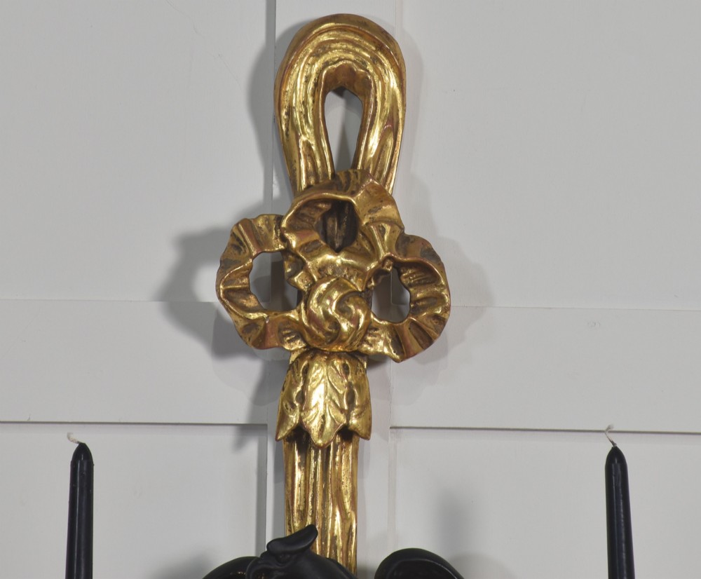 A pair of George III style giltwood wall sconces featuring carved ribbon crestings, dark eagle motifs, and twin candle arms. View IV