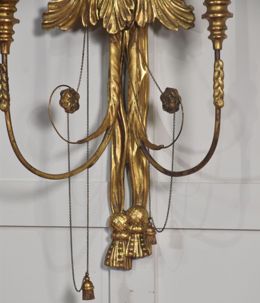 A pair of George III style giltwood wall sconces featuring carved ribbon crestings, dark eagle motifs, and twin candle arms. View VII