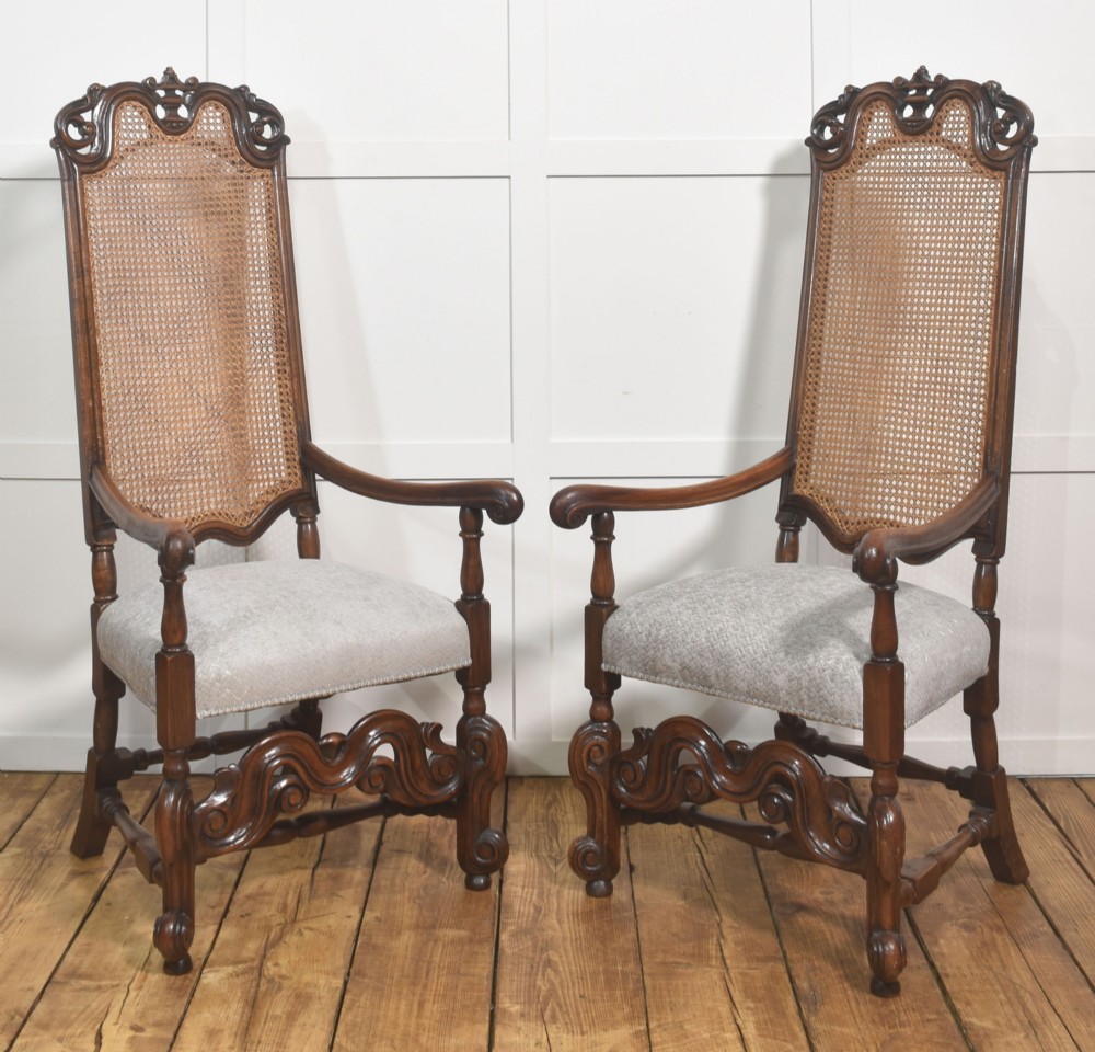 A set of eight walnut dining chairs featuring tall carved frames, woven cane back panels, grey upholstered seats, and scrollwork stretchers. View VI
