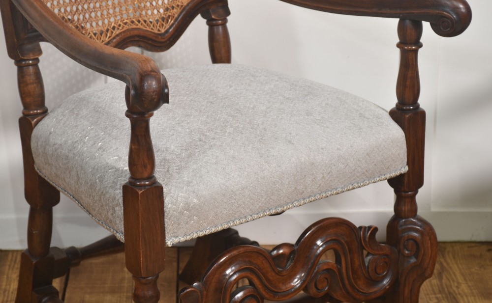 A set of eight walnut dining chairs featuring tall carved frames, woven cane back panels, grey upholstered seats, and scrollwork stretchers. View VII