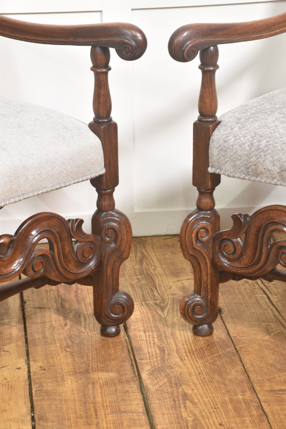 A set of eight walnut dining chairs featuring tall carved frames, woven cane back panels, grey upholstered seats, and scrollwork stretchers. View VIII